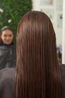 Portrait of a beautiful woman with long brown straight hair in a beauty salon. photo