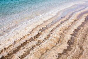 View of Dead Sea coastline at sunset time in Jordan. Salt crystals at sunset. Dead sea landscape with mineral structures. photo