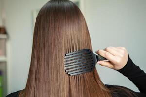 Portrait of a beautiful woman with long brown straight hair in a beauty salon. photo