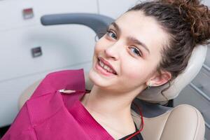 Young Female patient with pretty smile examining dental inspection at dentist clinic. Healthy teeth and medicine, stomatology concept photo