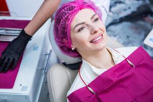 dentista examinando dientes de un joven mujer paciente en un dental clínica. odontología concepto. dentista y paciente en el dental oficina. foto