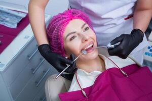 joven hembra paciente con bonito sonrisa examinando dental inspección a dentista clínica. sano dientes y medicamento, estomatología concepto foto