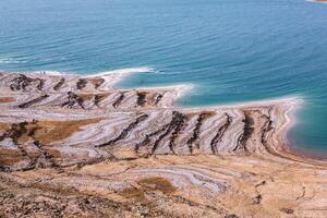 View of Dead Sea coastline at sunset time in Jordan. Salt crystals at sunset. Dead sea landscape with mineral structures. photo