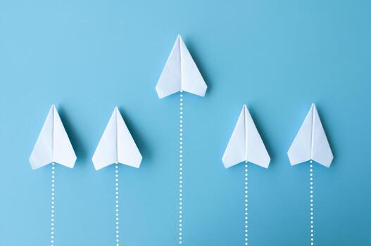 parte superior ver de blanco papel aviones origami volador en azul antecedentes foto