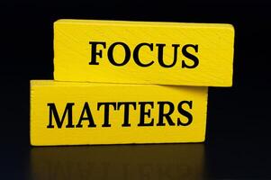 Focus matters text on yellow wooden blocks with dark cover background. Focusing concept photo