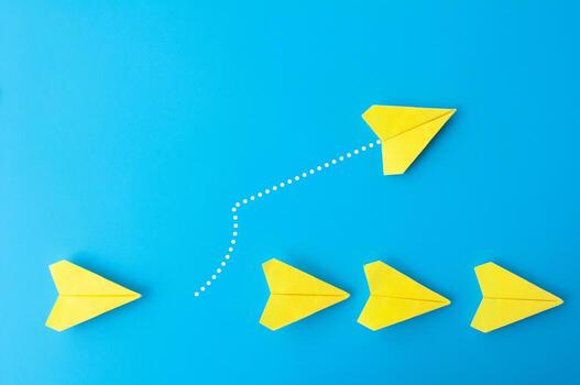 parte superior ver de amarillo papel aviones con uno volador a diferente dirección foto