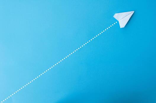 parte superior ver de papel avión con Derecho línea puntos en azul antecedentes foto