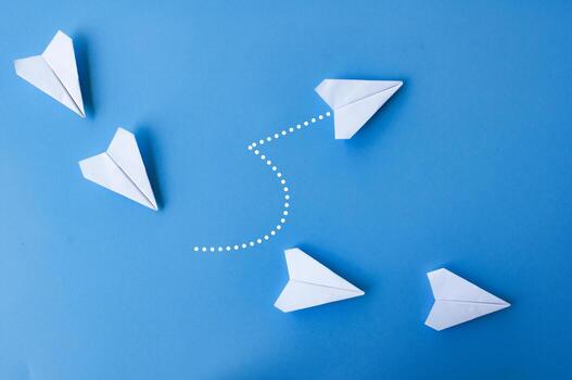 parte superior ver de blanco papel aviones origami con uno volador a diferente dirección. foto