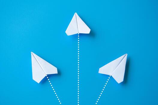 parte superior ver de blanco papel aviones origami volador a diferente dirección en azul antecedentes foto