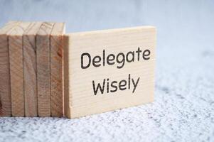 Delegate wisely text on wooden blocks. Delegation of duty concept photo