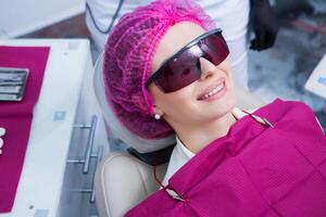 joven hembra paciente con bonito sonrisa examinando dental inspección a dentista clínica. sano dientes y medicamento, estomatología concepto foto
