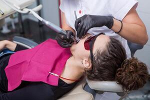 joven hembra paciente con bonito sonrisa examinando dental inspección a dentista clínica. sano dientes y medicamento, estomatología concepto foto