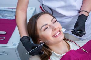 joven hembra paciente con bonito sonrisa examinando dental inspección a dentista clínica. sano dientes y medicamento, estomatología concepto foto