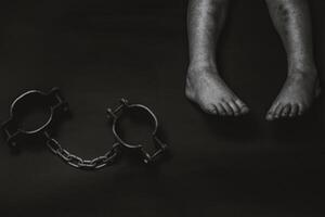 children's legs and shackles on a black background photo