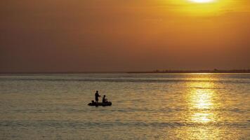 silhouette of rubber boat and golden sunset,Surin Island National park, Thailand photo