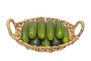 Fresh cucumbers in basket on wood photo