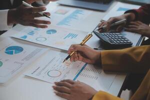 Financial analysts analyze business financial reports on a digital tablet planning investment project during a discussion at a meeting of corporate showing the results of their successful teamwork. photo