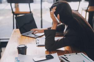 las mujeres asiáticas están estresadas mientras trabajan en una laptop, una mujer de negocios asiática cansada con dolor de cabeza en la oficina, se siente enferma en el trabajo, copia espacio foto