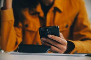 Asian businesswoman in formal suit in office happy and cheerful during using smartphone and working photo