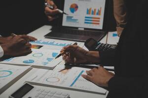 Financial analysts analyze business financial reports on a digital tablet planning investment project during a discussion at a meeting of corporate showing the results of their successful teamwork. photo