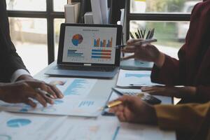 Financial analysts analyze business financial reports on a digital tablet planning investment project during a discussion at a meeting of corporate showing the results of their successful teamwork. photo