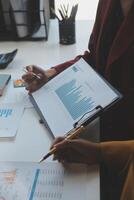 Financial analysts analyze business financial reports on a digital tablet planning investment project during a discussion at a meeting of corporate showing the results of their successful teamwork. photo