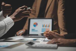 Financial analysts analyze business financial reports on a digital tablet planning investment project during a discussion at a meeting of corporate showing the results of their successful teamwork. photo