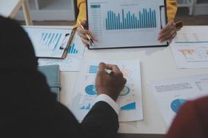 Financial analysts analyze business financial reports on a digital tablet planning investment project during a discussion at a meeting of corporate showing the results of their successful teamwork. photo