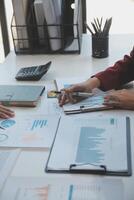 Financial analysts analyze business financial reports on a digital tablet planning investment project during a discussion at a meeting of corporate showing the results of their successful teamwork. photo