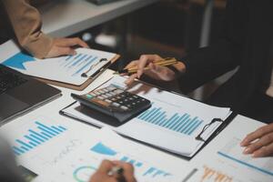 Financial analysts analyze business financial reports on a digital tablet planning investment project during a discussion at a meeting of corporate showing the results of their successful teamwork. photo