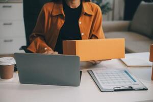 mujer de negocios comienzo pequeño negocio y exitoso SME empresarios asiático mujer hoding cajas trabajos desde hogar entregando parcelas en línea. SME entrega concepto y embalaje foto