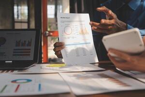 Close up of Business team analyzing income charts and graphs with modern laptop computer. Business analysis and strategy concept. photo