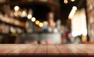 Empty wooden table top with lights bokeh on blur restaurant background. photo