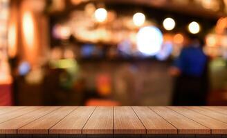 Empty wooden table top with lights bokeh on blur restaurant background. photo