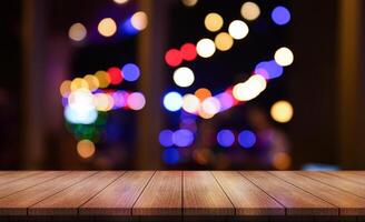 Empty wooden table top with lights bokeh on blur restaurant background. photo