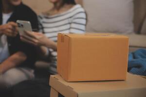 Two Asian blogger showing clothes in front of the camera to recording vlog video live streaming at her shop. Online Shopping Cart notion. on sofa at home photo