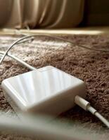 white charger left on a soft carpet floor. photo