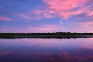 sereno aguas un feliz reflexión de un hermosa pastel lago y cielo, dónde tranquilidad Satisface de la naturaleza paleta, creando un armonioso oasis de suave matices y etéreo belleza foto