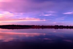 sereno aguas un feliz reflexión de un hermosa pastel lago y cielo, dónde tranquilidad Satisface de la naturaleza paleta, creando un armonioso oasis de suave matices y etéreo belleza foto