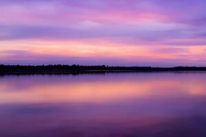 sereno aguas un feliz reflexión de un hermosa pastel lago y cielo, dónde tranquilidad Satisface de la naturaleza paleta, creando un armonioso oasis de suave matices y etéreo belleza foto