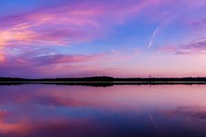 sereno aguas un feliz reflexión de un hermosa pastel lago y cielo, dónde tranquilidad Satisface de la naturaleza paleta, creando un armonioso oasis de suave matices y etéreo belleza foto