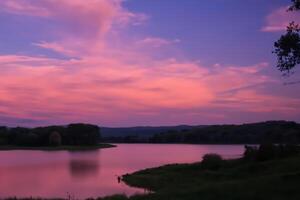 sereno aguas un feliz reflexión de un hermosa pastel lago y cielo, dónde tranquilidad Satisface de la naturaleza paleta, creando un armonioso oasis de suave matices y etéreo belleza foto