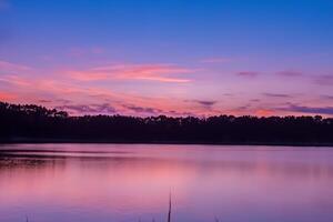 sereno aguas un feliz reflexión de un hermosa pastel lago y cielo, dónde tranquilidad Satisface de la naturaleza paleta, creando un armonioso oasis de suave matices y etéreo belleza foto