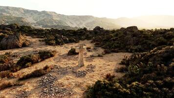 un devanado suciedad la carretera en el montañas con un cementerio cruzar en el distancia video