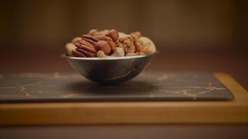 mezclado nueces de Almendras pacana nueces anacardos avellanas en de madera mesa video