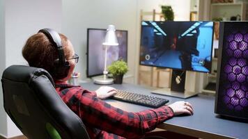 Side view of young female playing shooter games sitting on gaming chair. Powerful computer rig with neon spinning fans video