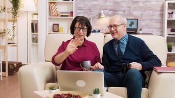 Couple of old people using modern technology. They are on a video call using laptop