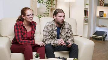 Man yelling at his girlfriend after losing while playing video games. Man using wireless controller.