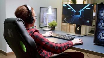 Enthusiastic woman sitting on gaming chair while playing games on powerful computer. video