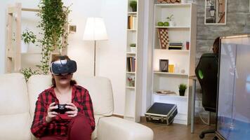 Young woman wearing vr headset while playing video games. Boyfriend sitting on gaming chair.